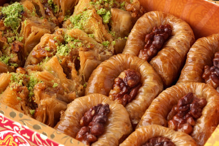 Delicious assortment of traditional Middle Eastern pastries displayed in an ornate box during a festive gatheringの写真素材