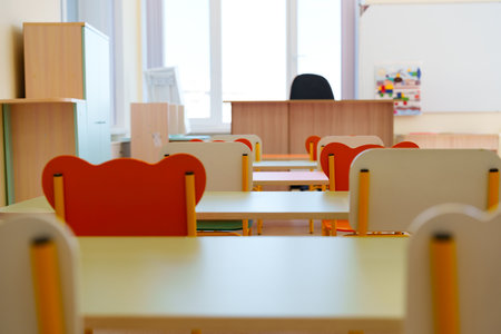 Bright and inviting classroom setup with colorful chairs and desks ready for students in a learning environmentの写真素材