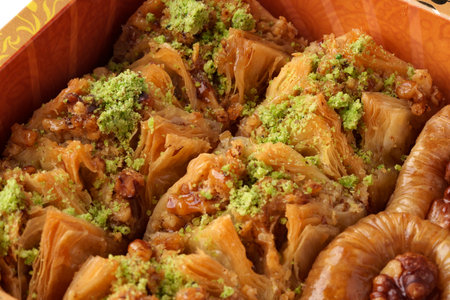 Sweet and flaky traditional pastry dessert served with pistachio topping in a decorative boxの写真素材