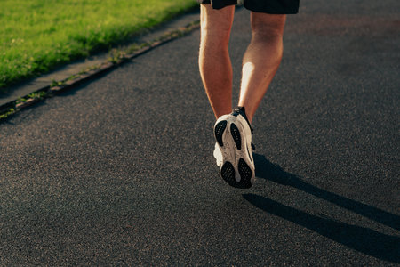 Running on a paved path in a sunny park during the morning hours for fitness and health