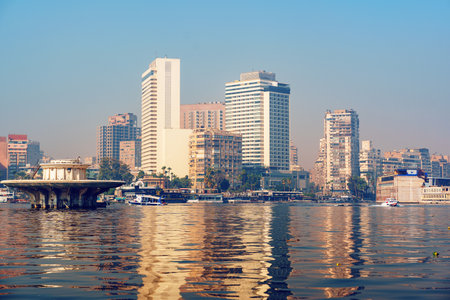 City skyline reflection on the Nile River with modern buildings in Cairo during a clear day