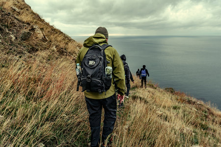 Hiking along a coastal trail with cloudy skies in the background on an overcast day
