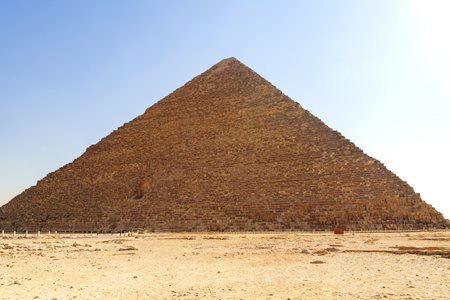 Majestic pyramid stands tall under bright sky at Giza, showcasing ancient Egyptian architecture and...