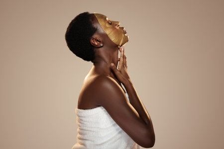 Woman applying face mask in relaxing setting for skincare routine self-care sessionの写真素材