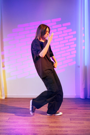 Energetic dance performance in modern studio with colorful lighting at night