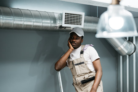Worker takes a break while preparing a workshop space in an industrial setting during the dayの写真素材