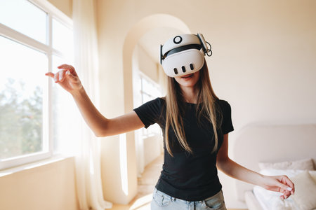 Woman engaging in virtual reality experience at home during daytime