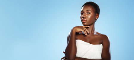 Model poses confidently against a light blue backdrop while showcasing natural beauty and eleganceの写真素材