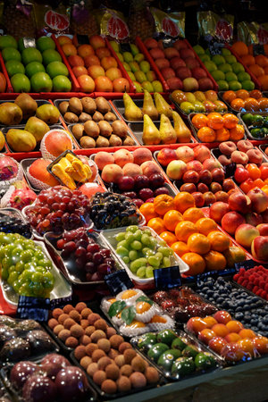 Vibrant fruit display at a bustling market during daylight in a lively urban settingの写真素材