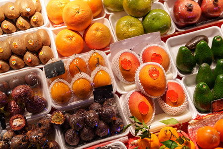 Colorful display of fresh fruits at a bustling market in a vibrant city during the daytimeの写真素材