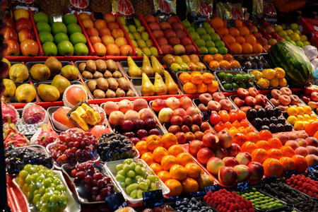 Colorful display of fresh fruits at a market during daytime in a vibrant communityの写真素材
