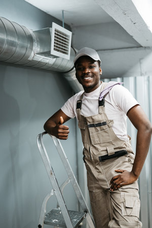 Skilled worker proudly completing installation in a modern building during daylight hoursの写真素材
