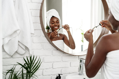 Woman applying skincare in modern bathroom with a warm and inviting atmosphere at morning time
