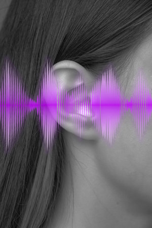 Sound wave visualization around a woman ear highlighting audio perception in a creative art...