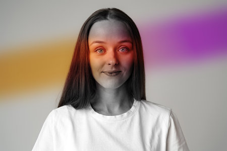 Portrait of a young woman with vibrant color accents in a minimalist studio setting, captured during afternoon lightの写真素材