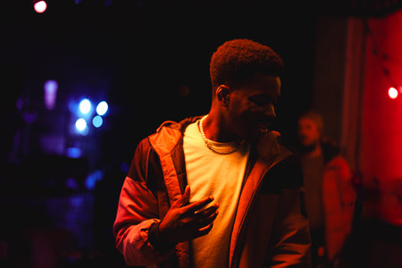 Vibrant night scene with a man enjoying music at a live event in a contrasting lit venue