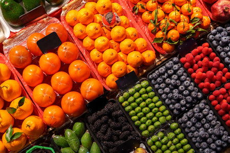 Colorful display of fresh fruits at a market showcasing a variety of seasonal produce in the afternoon lightの写真素材