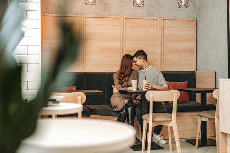 Couple enjoying an intimate moment in a cozy cafe during the afternoonの写真素材