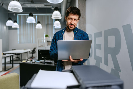 Man working on laptop in a modern office environment during daytime
