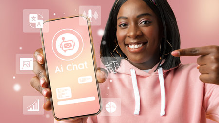 Young woman demonstrating AI chat application on smartphone against a pink background during a tech eventの写真素材