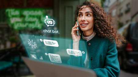 Woman engaged in conversation while using laptop in urban setting showcasing modern technology and communication toolsの写真素材