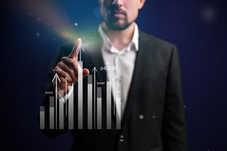 Business professional interacting with financial data in a modern setting during evening hoursの写真素材