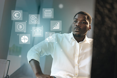 Professional man analyzing financial data and cryptocurrency trends in a modern office setting during daytimeの写真素材