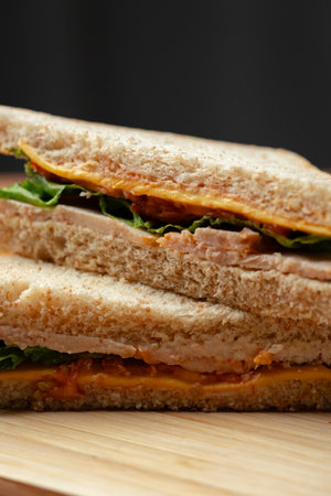Delicious vegetable and cheese sandwich made with whole grain bread served on a wooden board