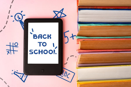 Preparing for a new school year with books and a tablet on a colorful backgroundの写真素材