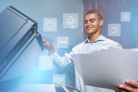 Man using a printer to copy documents in a modern office setting during the dayの写真素材