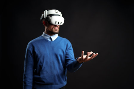 Man wearing virtual reality headset engages with digital environment in indoor studio setting