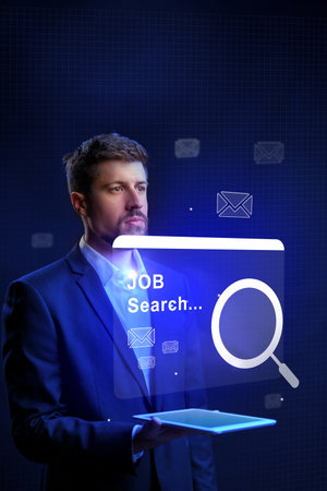 Professional man engaged in a digital job search with technology and virtual elements on displayの写真素材