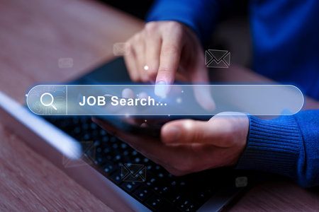 Searching for job opportunities on a mobile device during evening hoursの写真素材