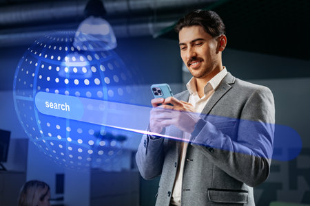 Professional man using smartphone to conduct online search in modern office setting during daytimeの写真素材