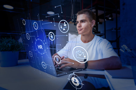 Young professional working on human resources tasks with digital interface in modern office settingの写真素材