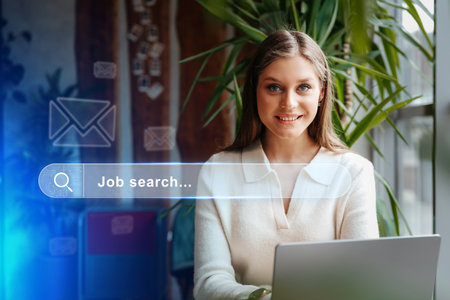 Young woman engaged in a job search, working on a laptop in a bright office space surrounded by plantsの写真素材