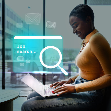 Woman engaged in job search using laptop in modern office environment during daytimeの写真素材