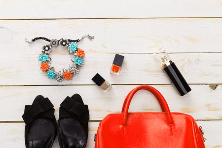 Woman handbag contents spilled out on wooden table