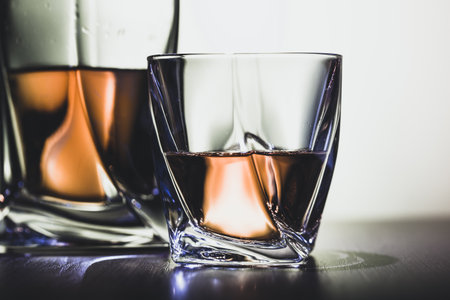 Glass of the whiskey or cognac on table in the dark