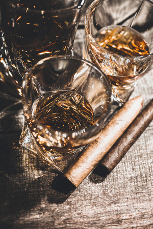 Glasses of whiskey on old dark wooden table