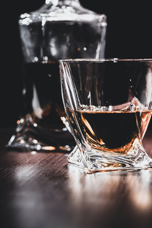Glass of the whiskey or cognac on table in the dark