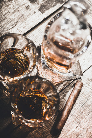 Two whiskey glasses close up on old wooden table