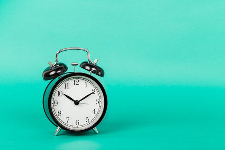 Alarm clock on green background close up