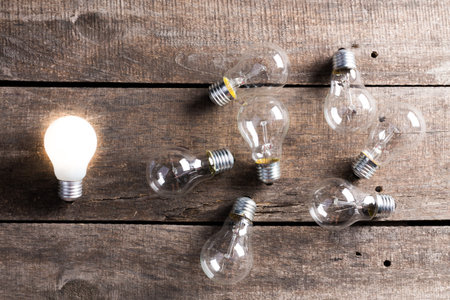 Electrical light bulb over wooden background close up
