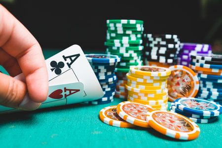 Chips and cards for poker on green table with bokeh