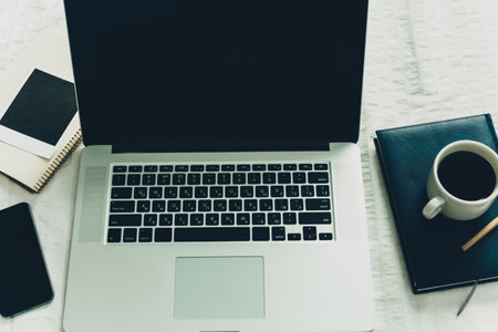 Workplace with laptop, notepad and coffee cup on white background