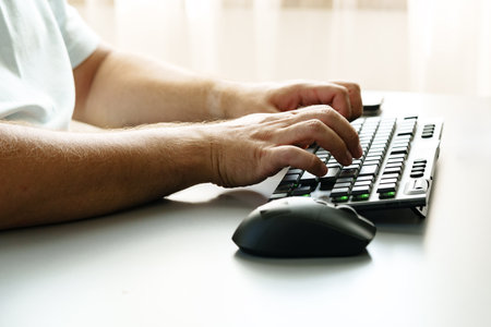 Person typing on a keyboard with a mouse beside on a minimal workspace desk