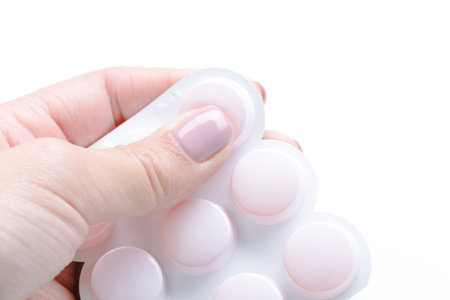Squeezing silicone molds with pastel-colored nail polish on fingers