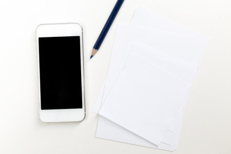 Mobile device and stationary materials on a clean workspace surfaceの写真素材