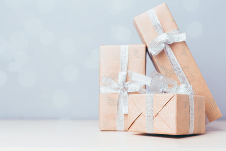 Holiday gift boxes arranged on a soft surface with a subtle sparkling background